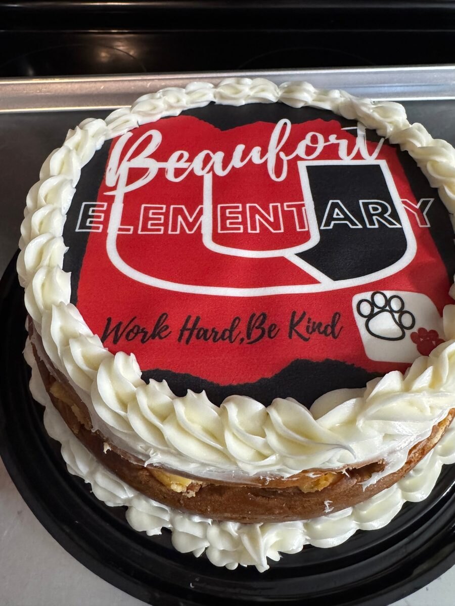 Custom edible image cheesecake with a school logo.